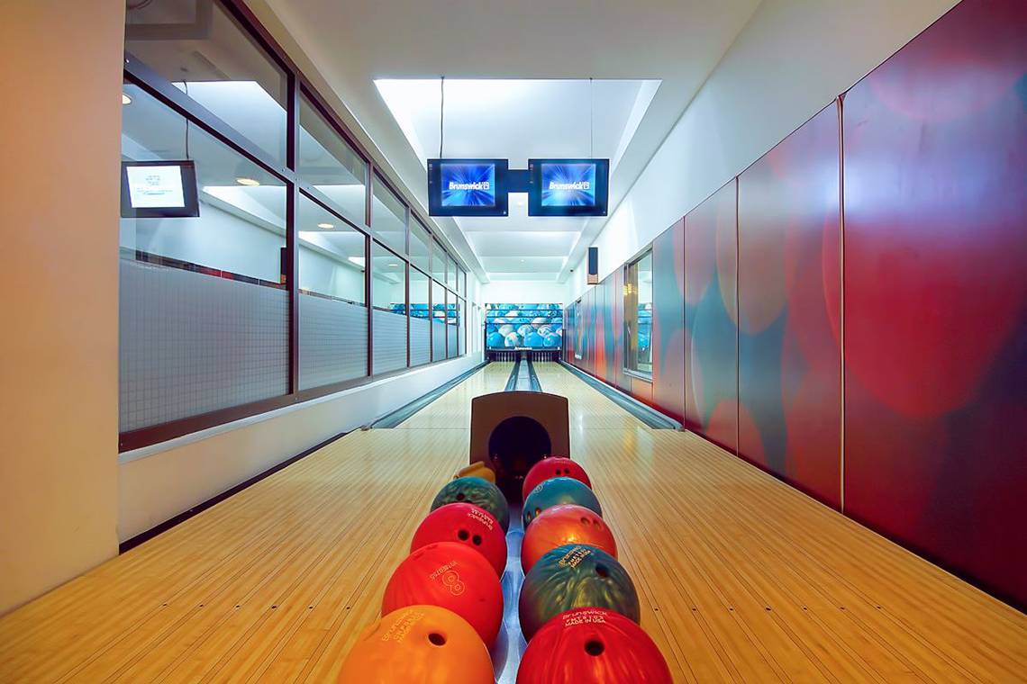 Innenansicht der Bowlinghalle im Baia Lara Hotel mit Bowlingbahnen, Kegel und Monitoren.