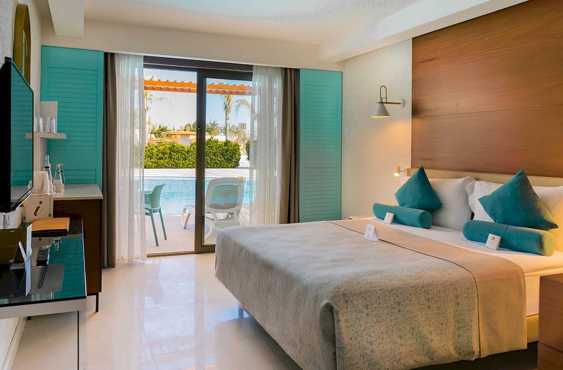 Schlafzimmer im Baia Lara Hotel mit Blick auf den Pool und Außenbereich.