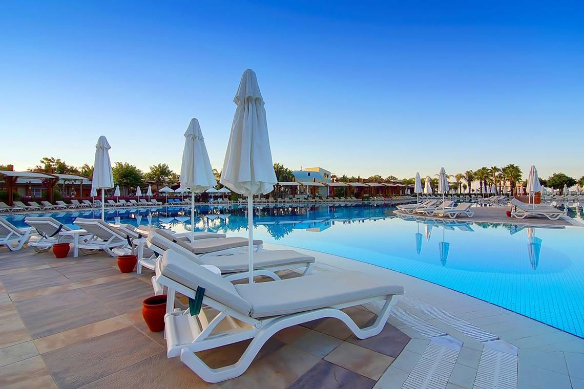 Außenbereich des Baia Lara Hotels mit Lounge-Stühlen und Sonnenschirmen am Pool