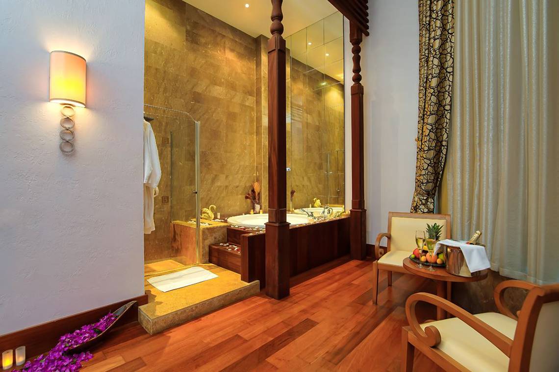 Badezimmer im Baia Lara Hotel mit Badewanne, Sitzecke und Obstkorb auf einem Tisch.