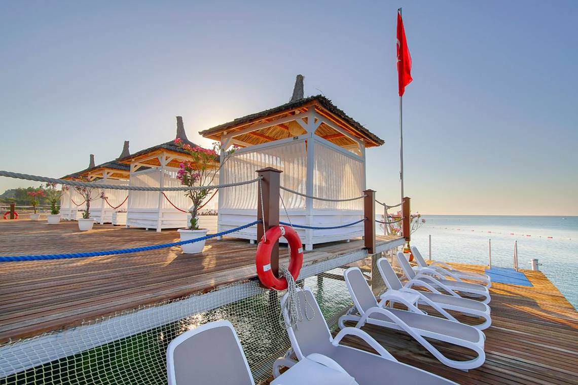Außenbereich des Baia Lara Hotels mit Strandliegen und Sonnenschirmen am Meer