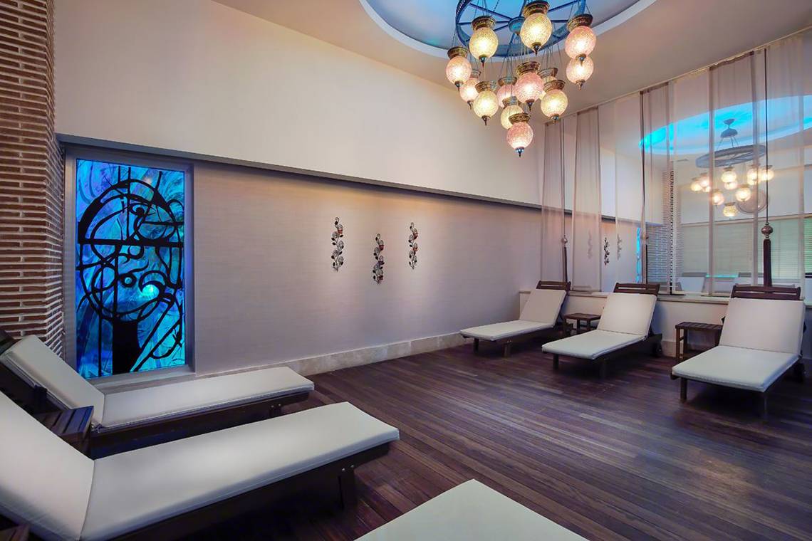 Loungebereich im Baia Lara Hotel mit weißen Liegen und einem blauen Kunstfenster.