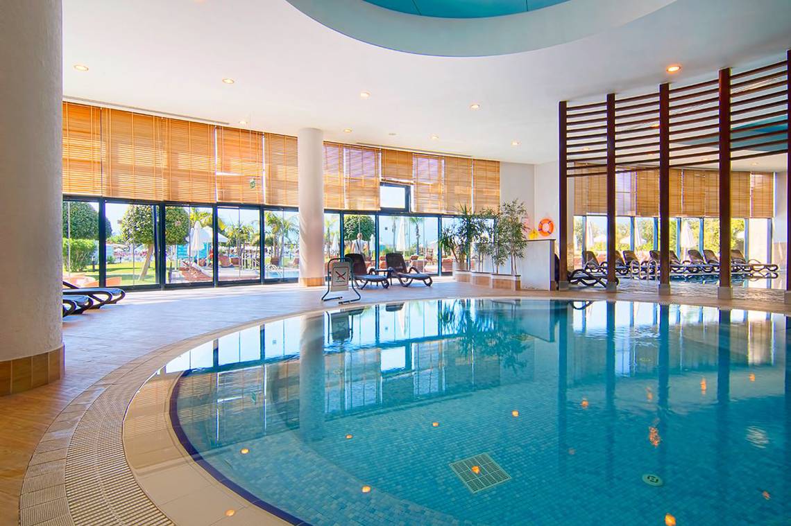 Innenpool im Baia Lara Hotel mit Lounge-Liegen und Panoramafenstern