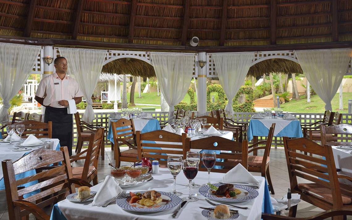 Innenansicht des Restaurants im Sol Palmeras Hotel mit einem Kellner, der an einem Tisch steht.
