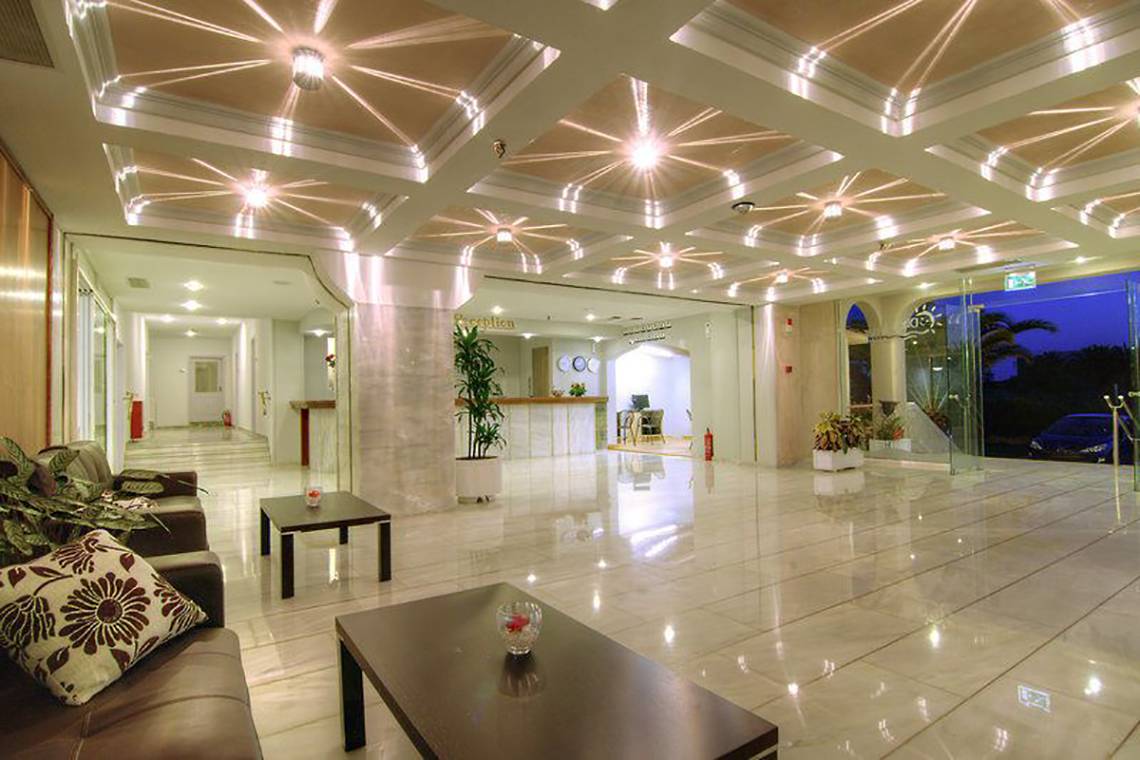 Empfangsbereich des Solimar Dias Hotels mit weiß glänzendem Boden und modernen Leuchten an der Decke.