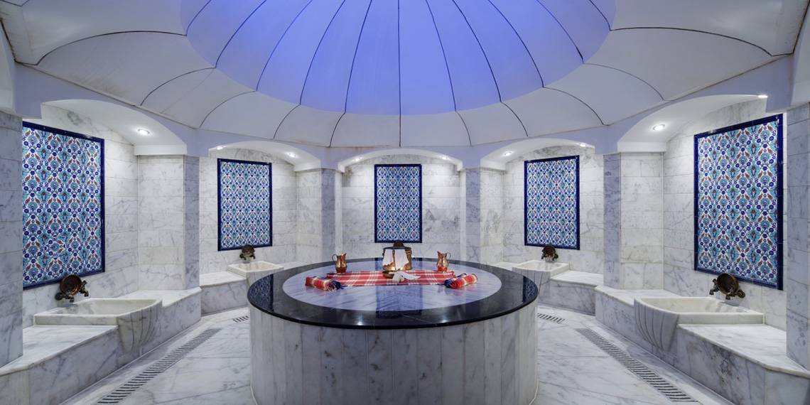 Innenansicht der Sauna im Liberty Hotels Lara mit blauen Mustern an den Wänden und einer zentralen Rundbank.