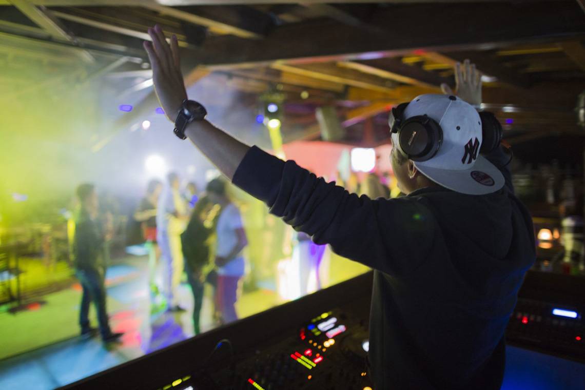 DJ in einem Club bei Liberty Hotels Lara, der auf eine tanzende Menge schaut.