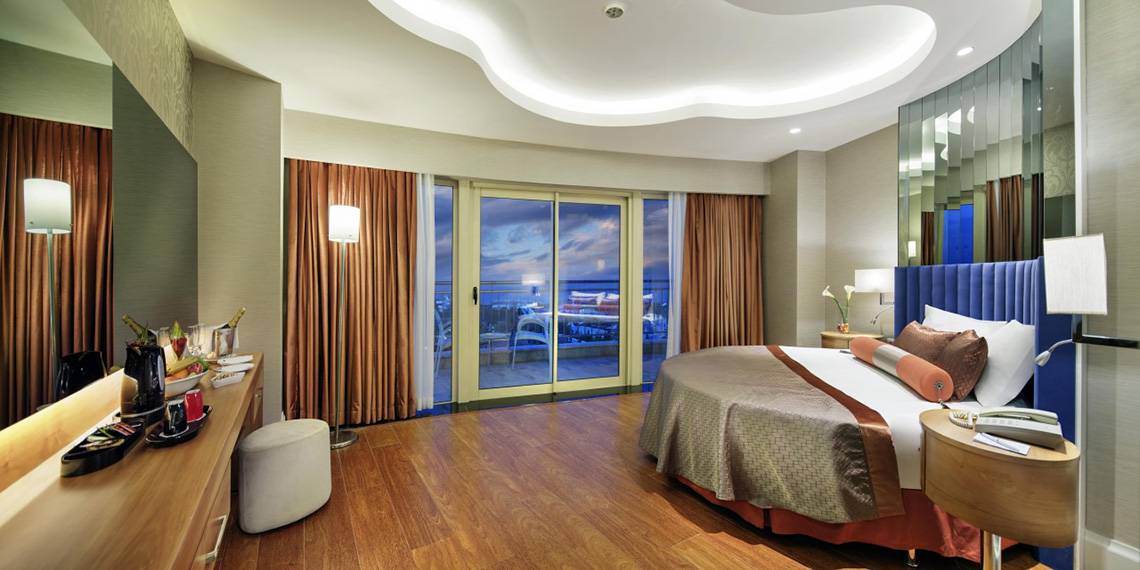 Schlafzimmer im Liberty Hotels Lara mit großem Bett und Aussichtsfenstern.