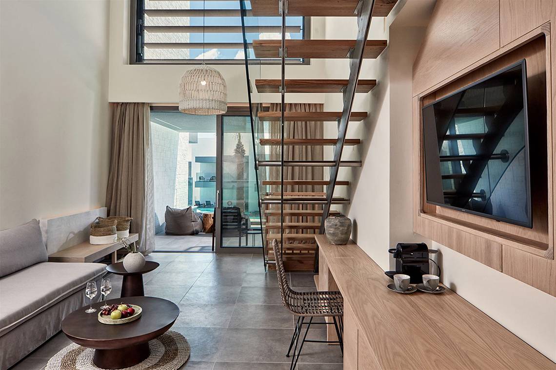 Innenraum des Atlantica Dreams Resort mit Sofa, Tisch und Treppe.