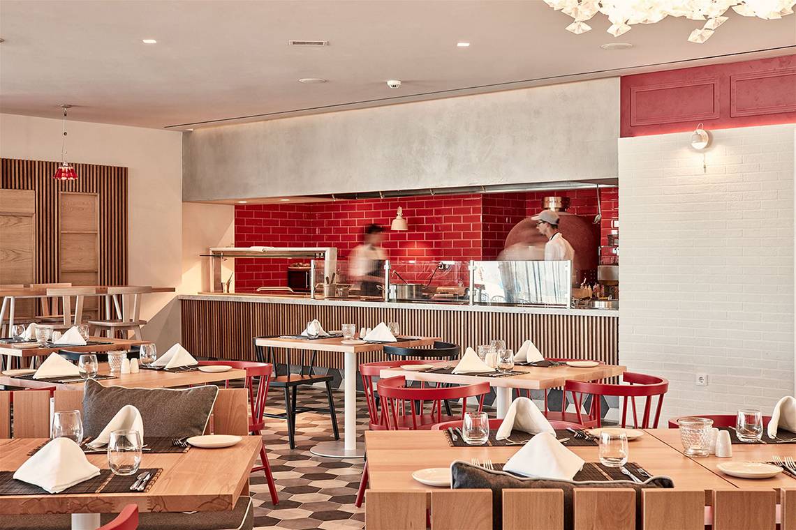 Innenansicht des Restaurants im Atlantica Dreams Resort mit roter Wand und Holztischen