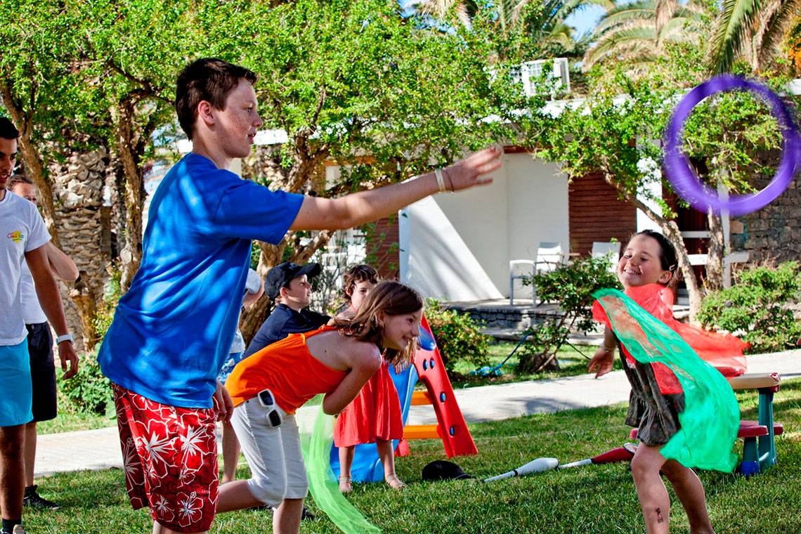 Kinder spielen mit Hula-Hoop-Ringen im Garten des Civitel Creta Beach Hotels.