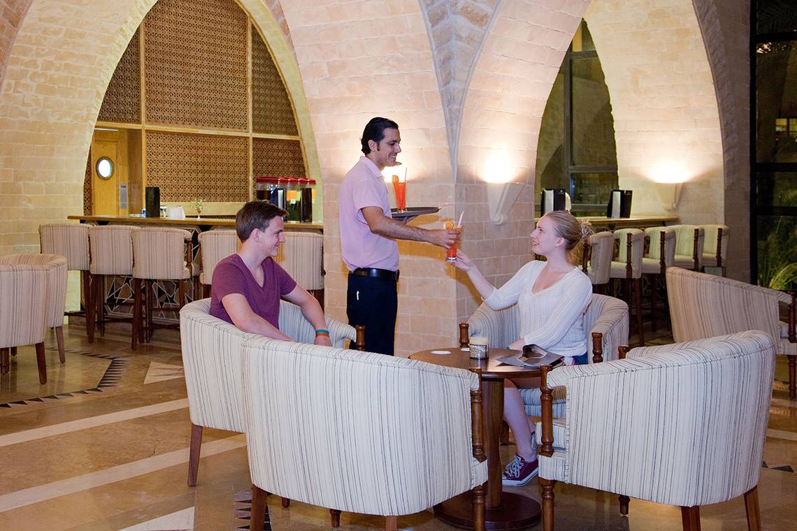 Ein Barkeeper serviert Getränke in einem eleganten Hotelrestaurant.