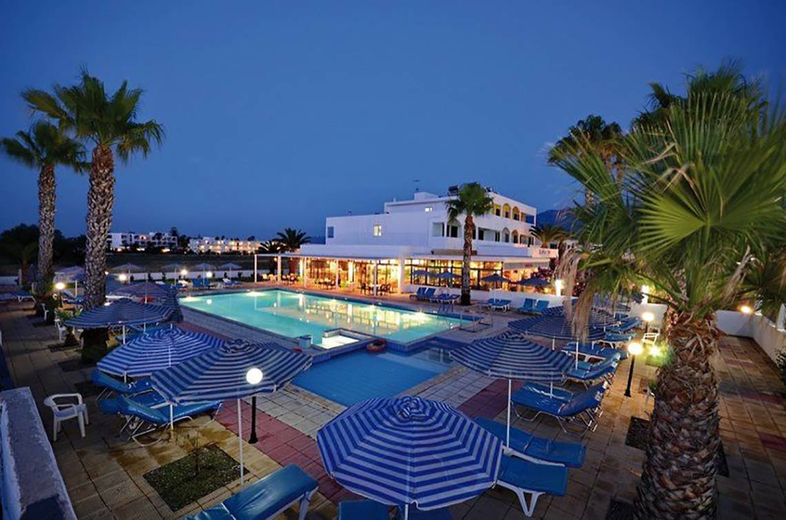 Nachtansicht des Tropical Sol Hotels mit Swimmingpool und Sonnenliegen