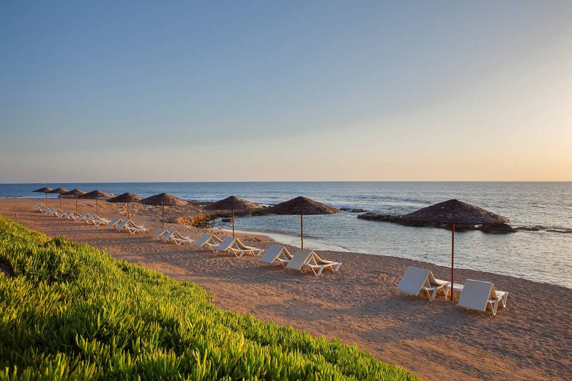 Strand des Louis Imperial Beach Hotels mit Sonnenliegen und Sonnenschirmen am Meer