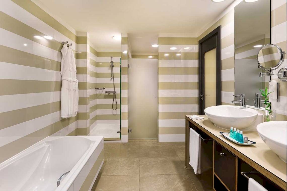 Badezimmer im Jardines de Nivaria Hotel mit Badewanne, Dusche und Waschbecken.