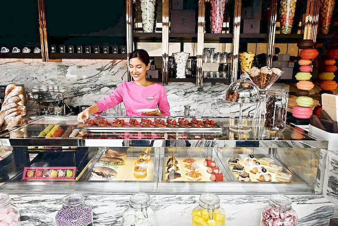 Eine Angestellte serviert Desserts in der Konditorei des Sofitel Bangkok Sukhumvit Hotels.