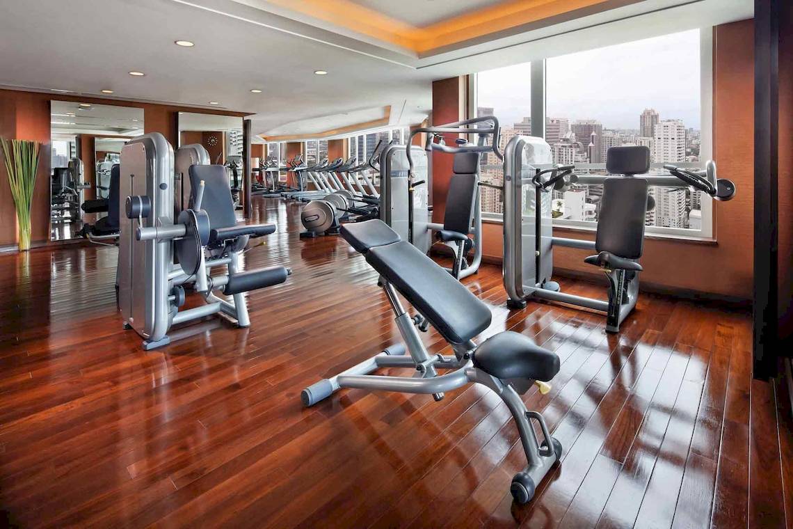 Fitnesscenter im Sofitel Bangkok Sukhumvit mit Geräten und Ausblick auf die Stadt.