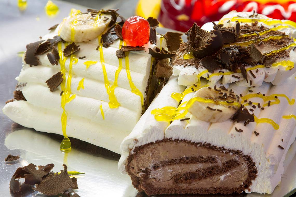 Nahaufnahme eines Dessertstücks vom Kresten Palace, mit weißer Creme, Bananenscheiben, gelber Glasur und Schokoladenstücken.