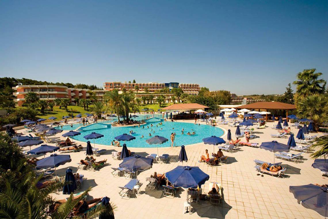 Luftaufnahme des Kresten Palace Hotels mit Swimmingpool, Liegestühlen und Gästen unter Sonnenschirmen.