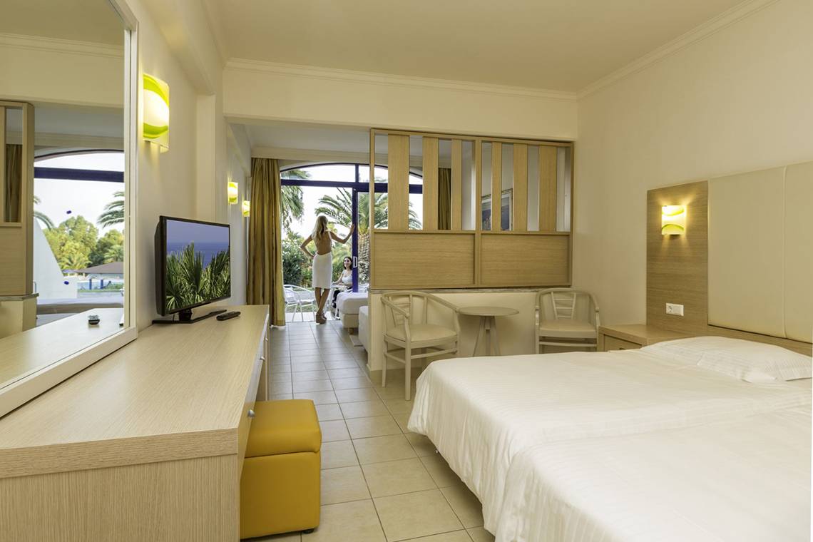 Ein Hotelzimmer im Kresten Palace Hotel mit einem Bett, Fernseher und einem großen Fenster.