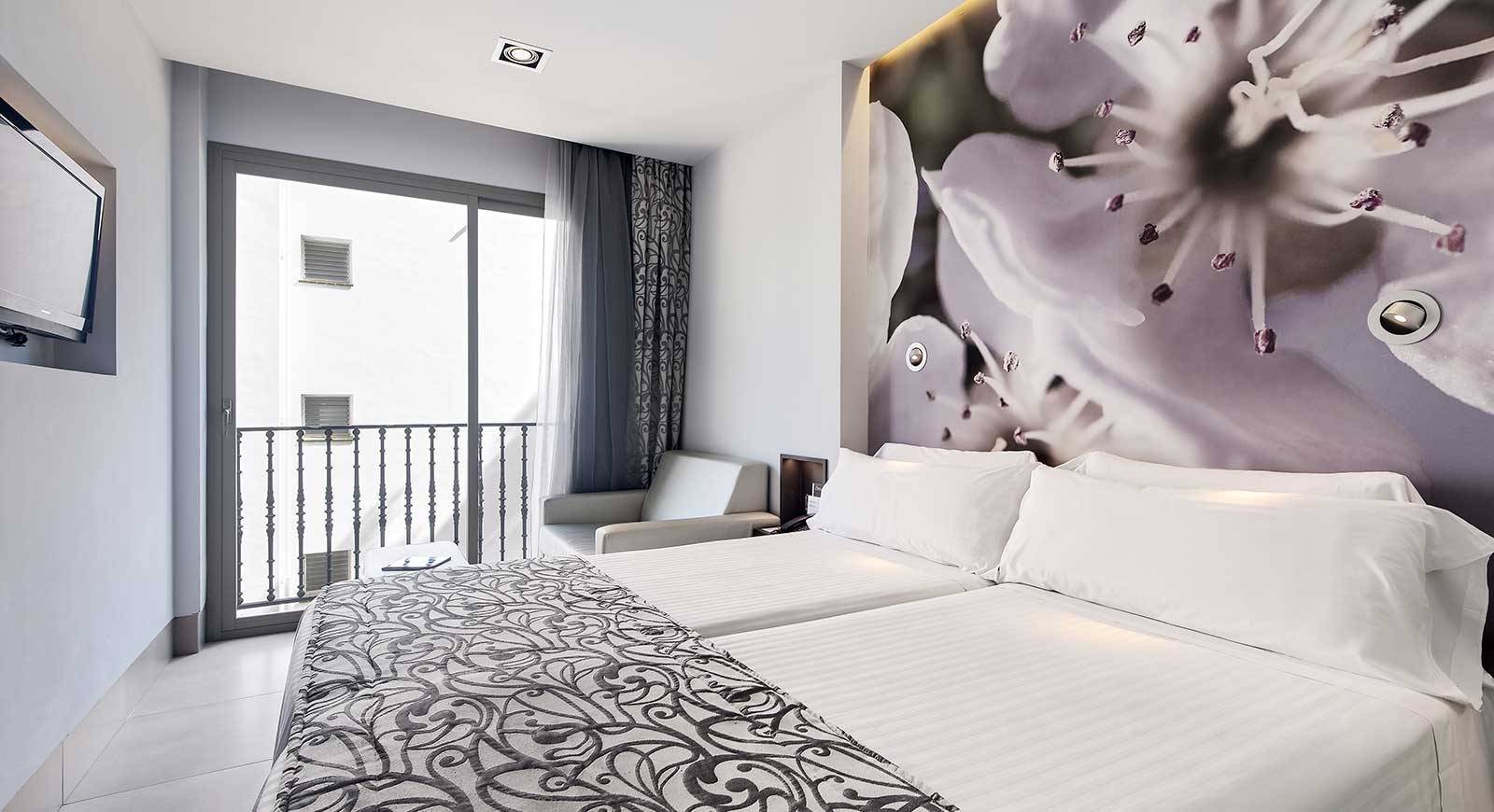 Hotelzimmer mit zwei Betten, Balkon, Sessel und Fernseher