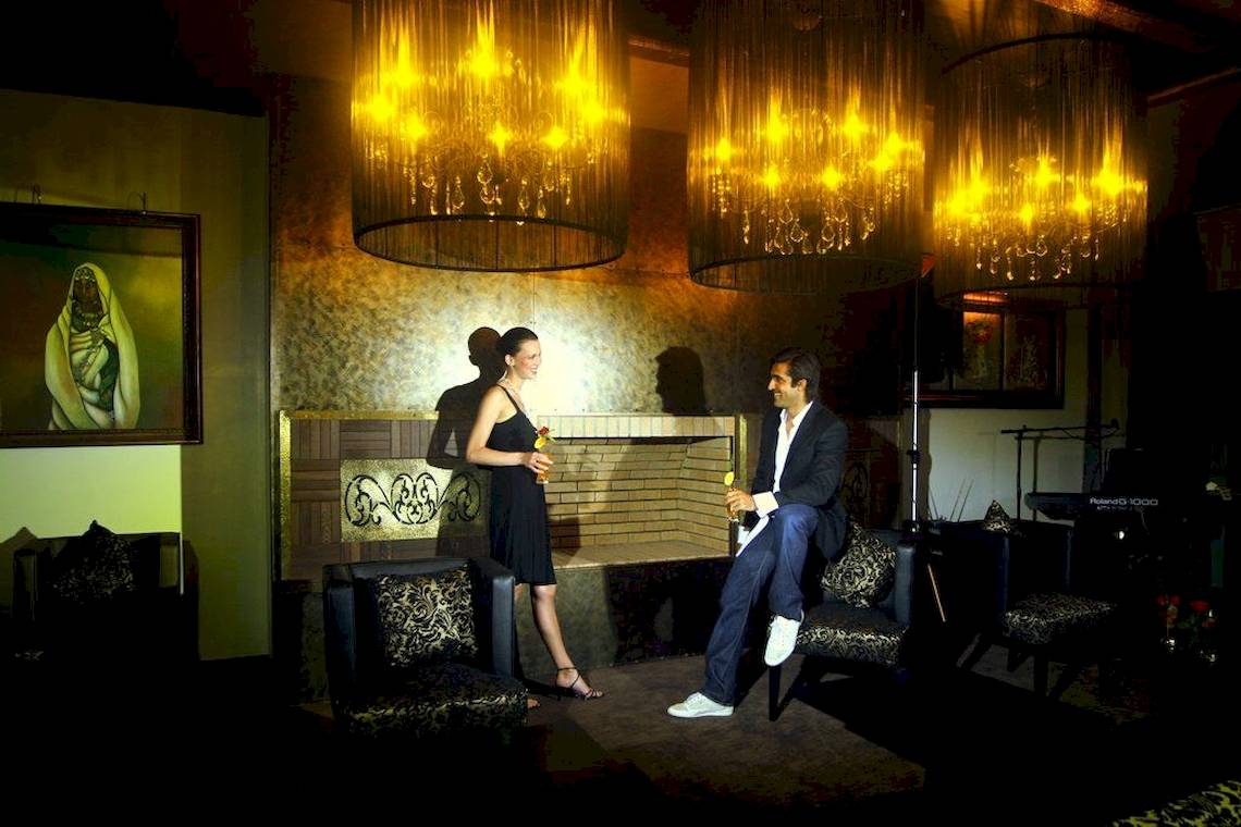Ein Paar im Royal Atlas & Spa Hotel Lounge mit Kronleuchtern und Kamin