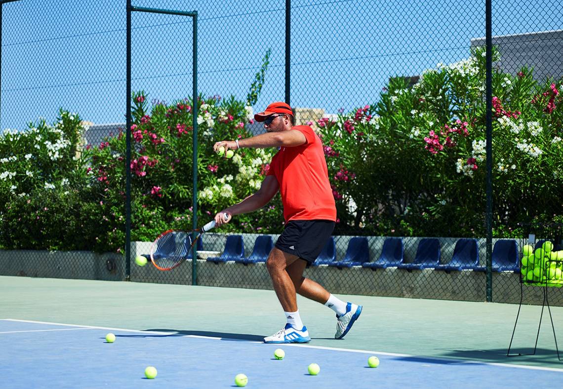 Tennisspieler am Tennisplatz im Ikaros Beach Luxury Resort & Spa.