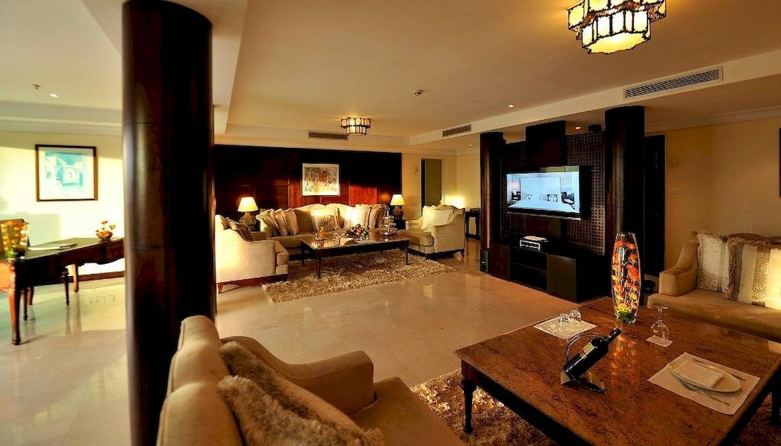 Wohnbereich des Sofitel Agadir Royal Bay Resort mit Möbeln, Fernseher und Lampen.