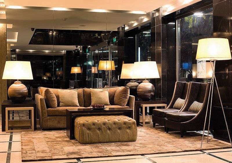Hotellobby mit einem großen Sofa, Lampen und einem Teppich auf dem Boden.