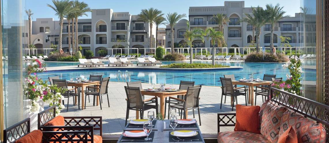 Aussenbereich des Steigenberger Alcazar Hotels mit Swimmingpool und Esstischen