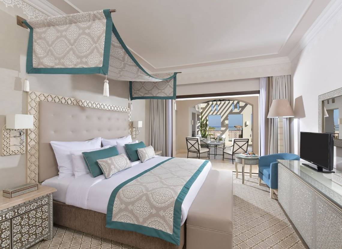Ein elegantes Hotelzimmer im Steigenberger Alcazar mit einem großen Bett und modernen Möbeln.