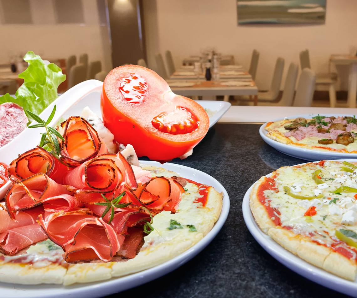 Servatur Waikiki Hotel Speisen auf einem Tisch mit verschiedenen Pizzen und Beilagen.