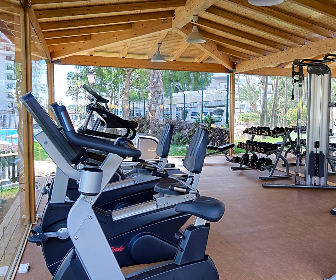 Fitnessstudio im Servatur Waikiki Hotel mit Cardiogeräten und Hanteln.