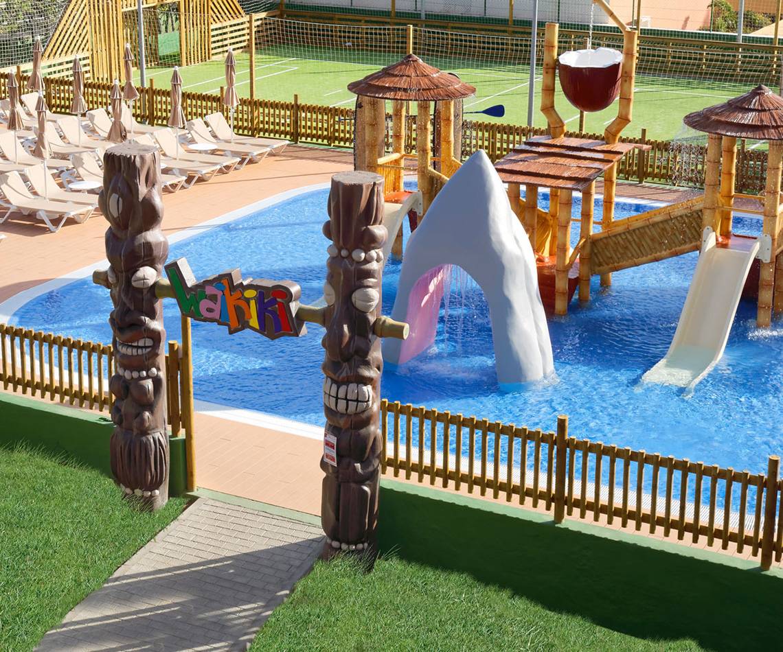 Außenansicht des Wasserparks im Servatur Waikiki Hotel mit Rutschen und Wasserspielgeräten.