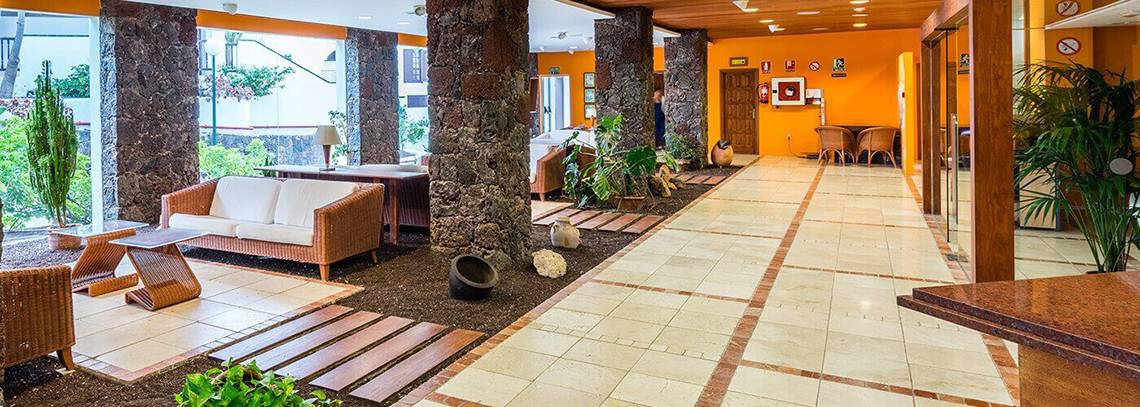 Lobby des BLUESEA Callao Garden Hotels mit Möbeln und Pflanzen.