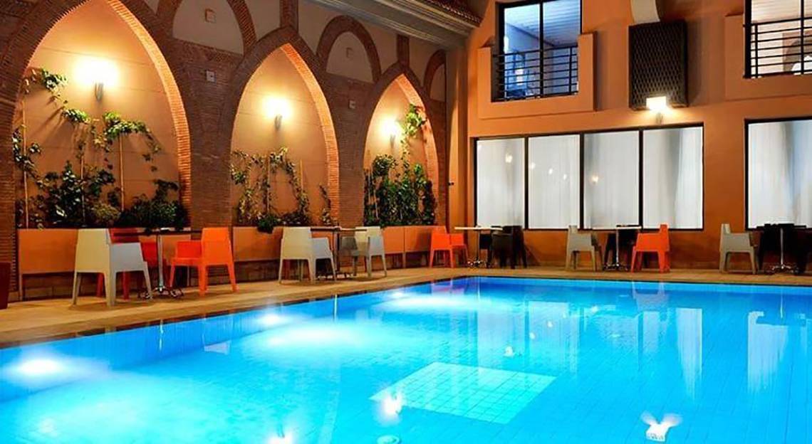Innenpool des Bluesea Callao Garden Hotels mit bunten Stühlen und Tischen