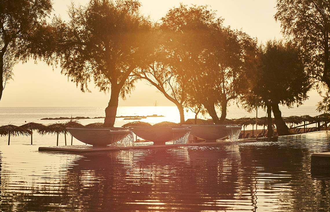 Sonnenuntergang am Pool des Grecotel Casa Marron Hotels mit Wasserfontaenen und Meersicht