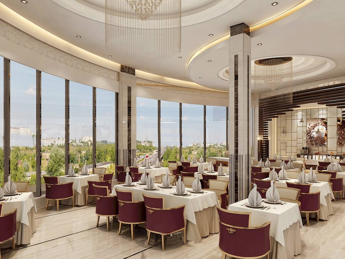 Restaurant im Belad Bont Resort mit Panoramafenstern und Ausblick auf die Stadt.