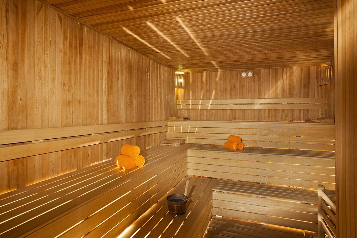 Sauna im Roma Beach Resort & Spa mit Holzbänken und Handtüchern.