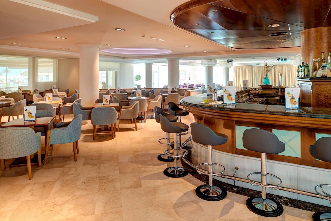 Innenbereich der Bar im Hipotels Hipocampo Playa Hotel mit vielen Tischen und Stühlen.