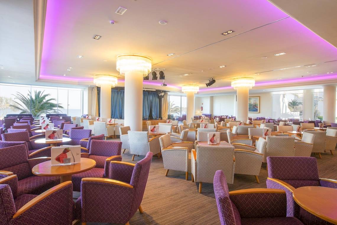 Loungebereich des Hipotels Hipocampo Playa Hotel mit violetten Beleuchtung und Sitzgruppen.