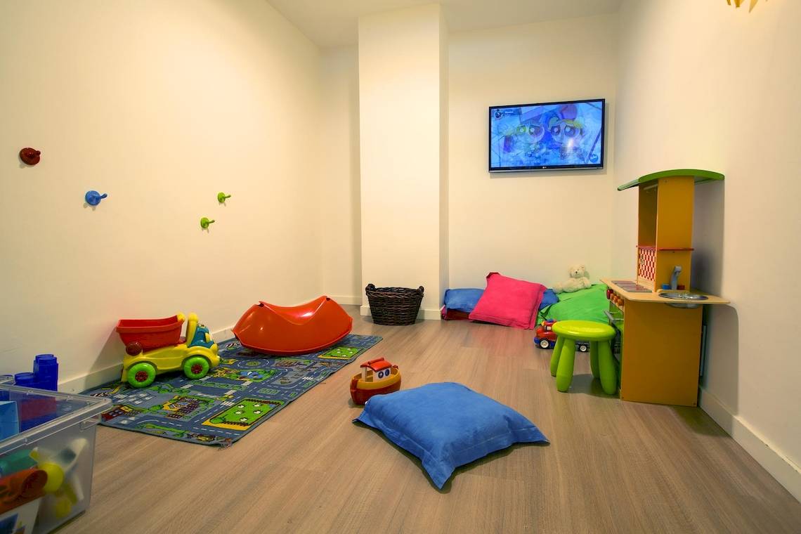 Ein Kinderzimmer mit Spielzeug, einem Fernseher und verschiedenen Möbeln.