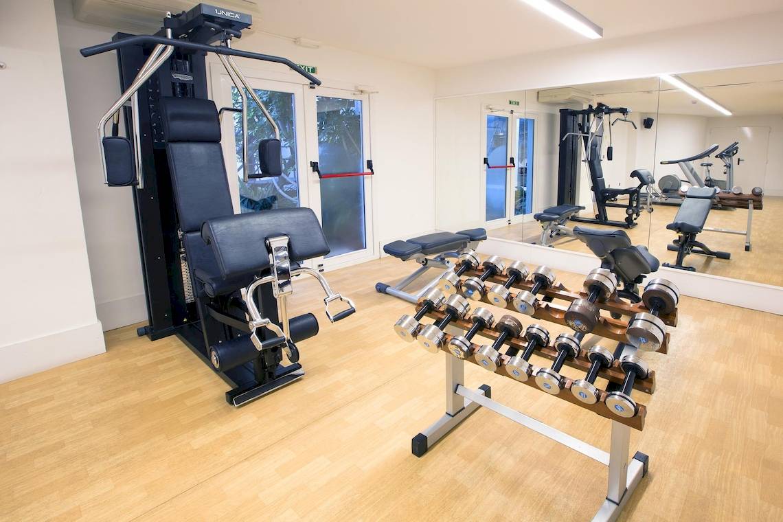 Fitnessraum im Hipotels Hipocampo Playa mit Hanteln und Trainingsgeräten.