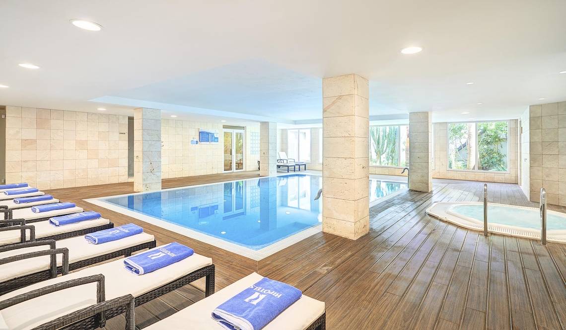 Innenpool im Hipotels Hipocampo Playa mit Loungeliegen und Blick auf Außenpool