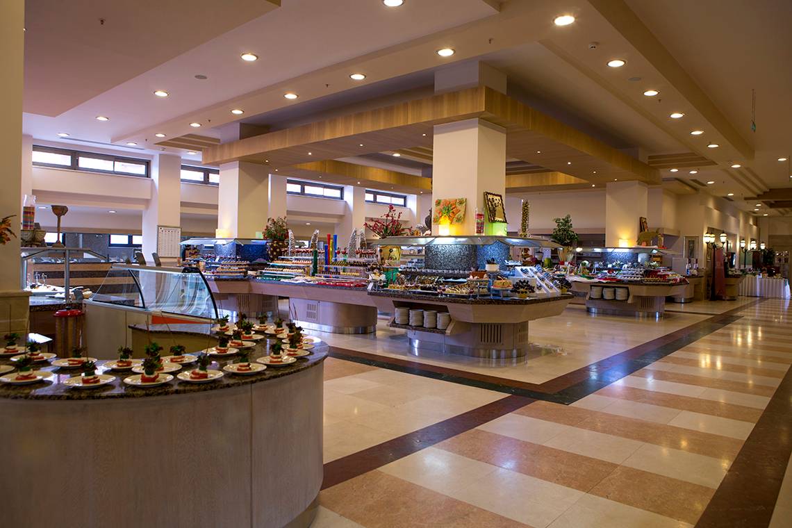 Buffet-Restaurant im Fame Residence Lara & Spa Hotel mit vielen Speisen und Tischen.