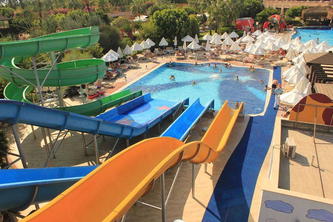 Luftaufnahme von Fame Residence Lara & Spa mit mehreren Wasserrutschen und einem großen Pool.