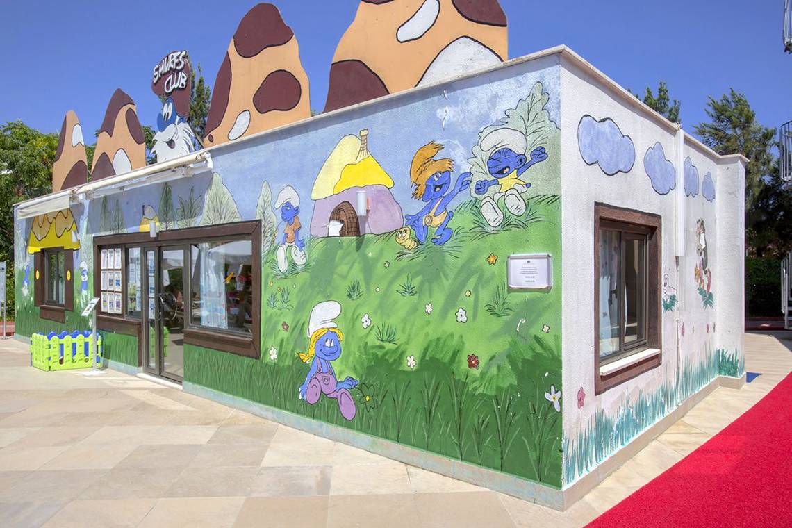 Außenansicht des Smurfs Club Gebäudes mit bunter Wandmalerei und Eingang