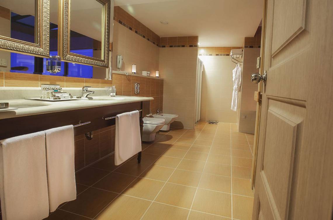 Badezimmer mit zwei Waschtischen, zwei Toiletten und Handtüchern im Fame Residence Lara & Spa Hotel.