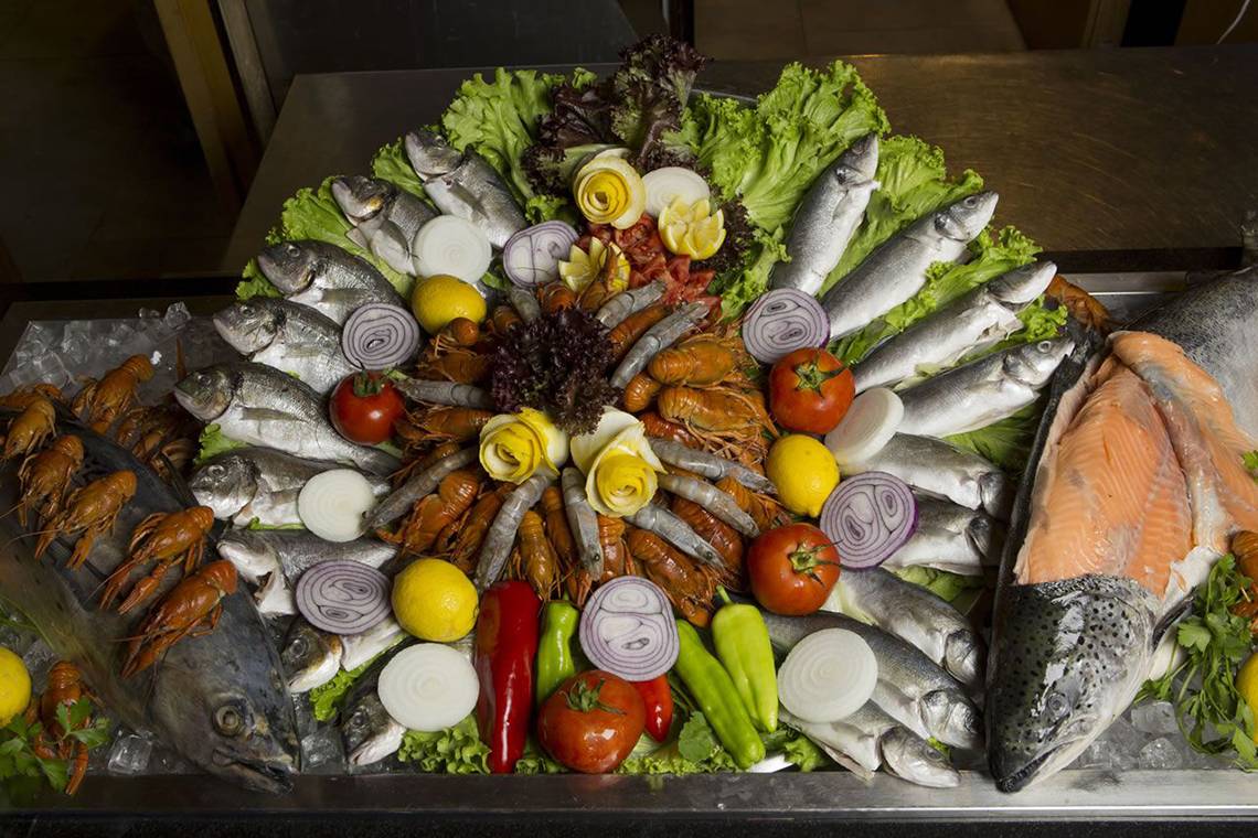 Präsentation verschiedener Fisch- und Meeresfrüchte auf einem Eisblock.