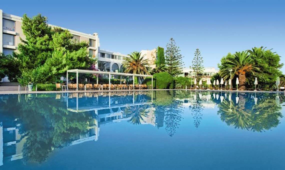 Außenbereich des Caravia Beach Hotel mit Swimmingpool und Sonnenliegen